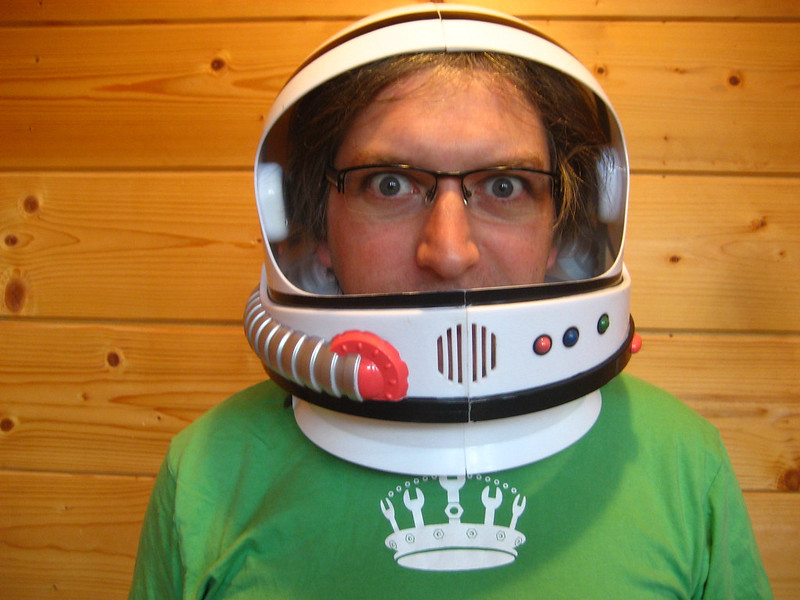 Jeremy Keith wearing glasses and a toy space helmet with a green t-shirt