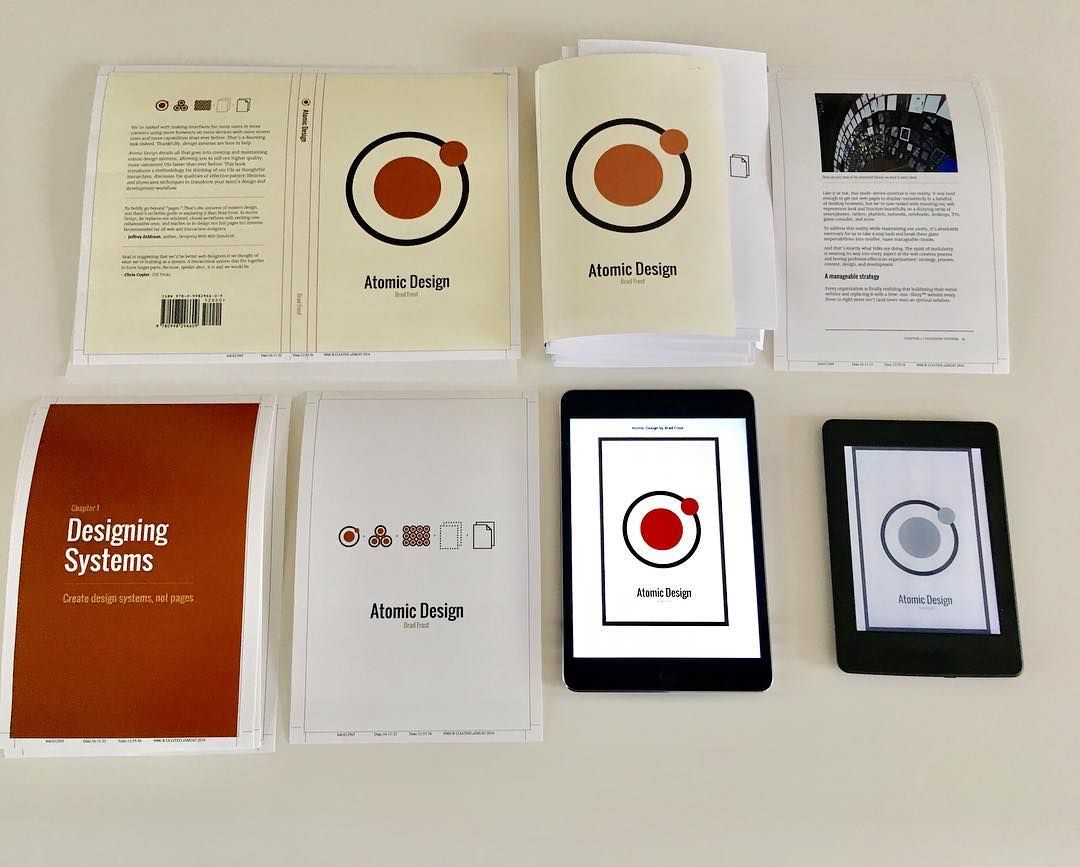 The Atomic Design paperback, the ebook on tablets, and stickers laid out on a table