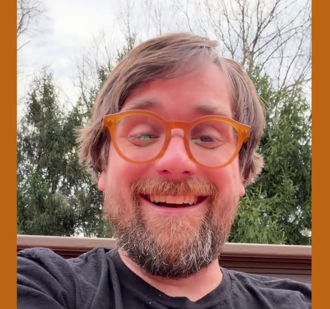 Still of Brad creating his new website with a funky visualization with the words "we are here. we are alive." sitting on top of it.