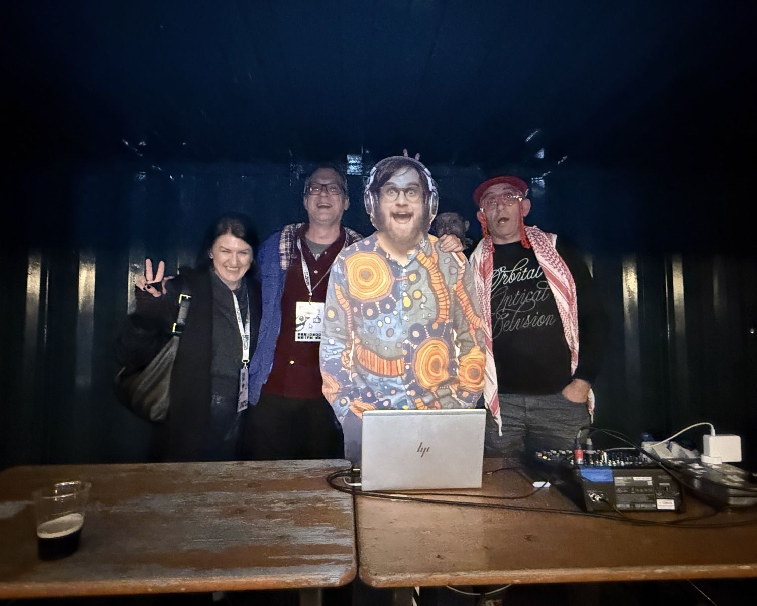 A cardboard cutout of Brad Frost behind a DJ station, with Dave Letorey and two people posing with it
