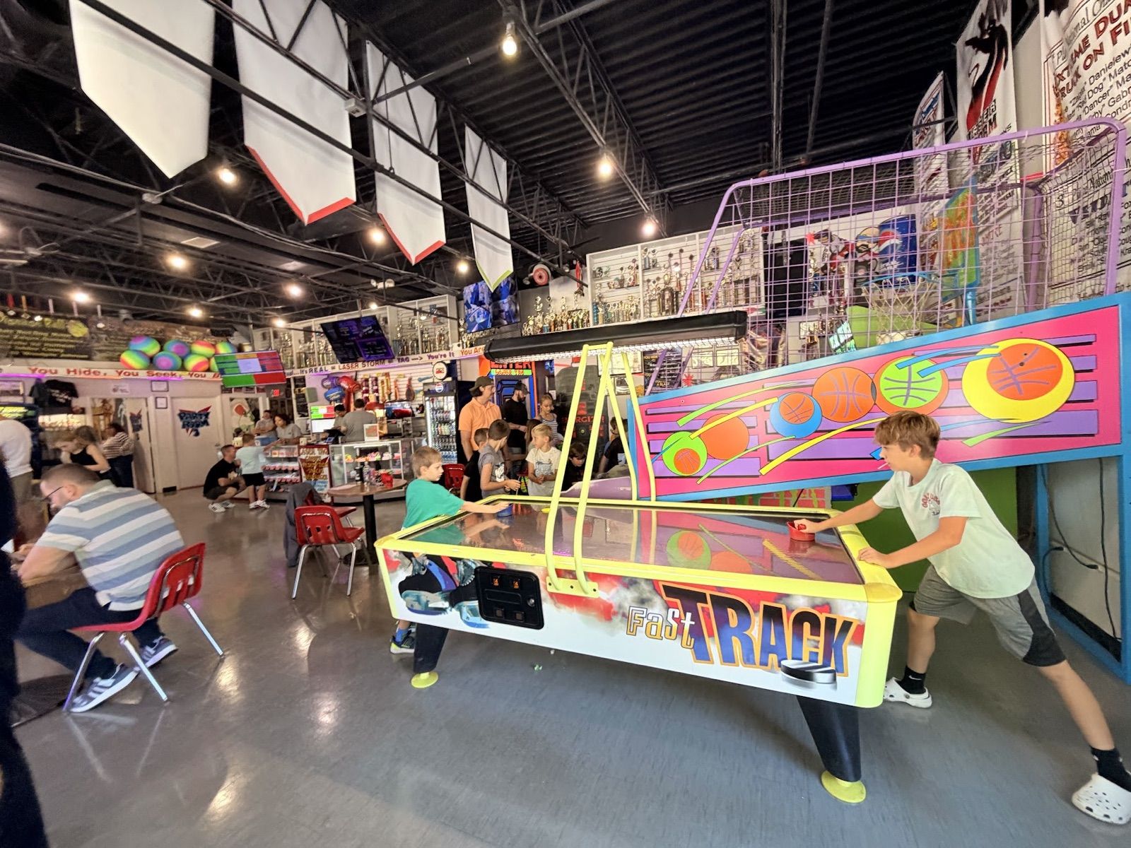 Two kids playing air hockey on a "Fast Track" table