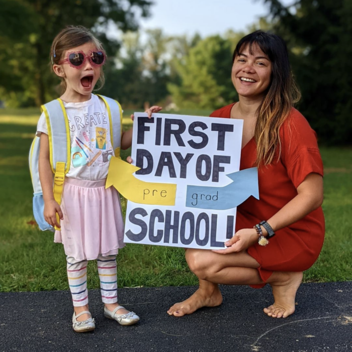 Melissa and Ella starting school. I made a poster that said "First day of pre/grad school"