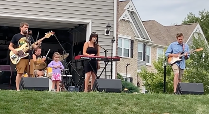 Brad playing bass, Ian playing drums, Melissa playing keyboard, and Taylor playing guitar. 4-year-old Ella stands in between her parents serving as a backup dancer.