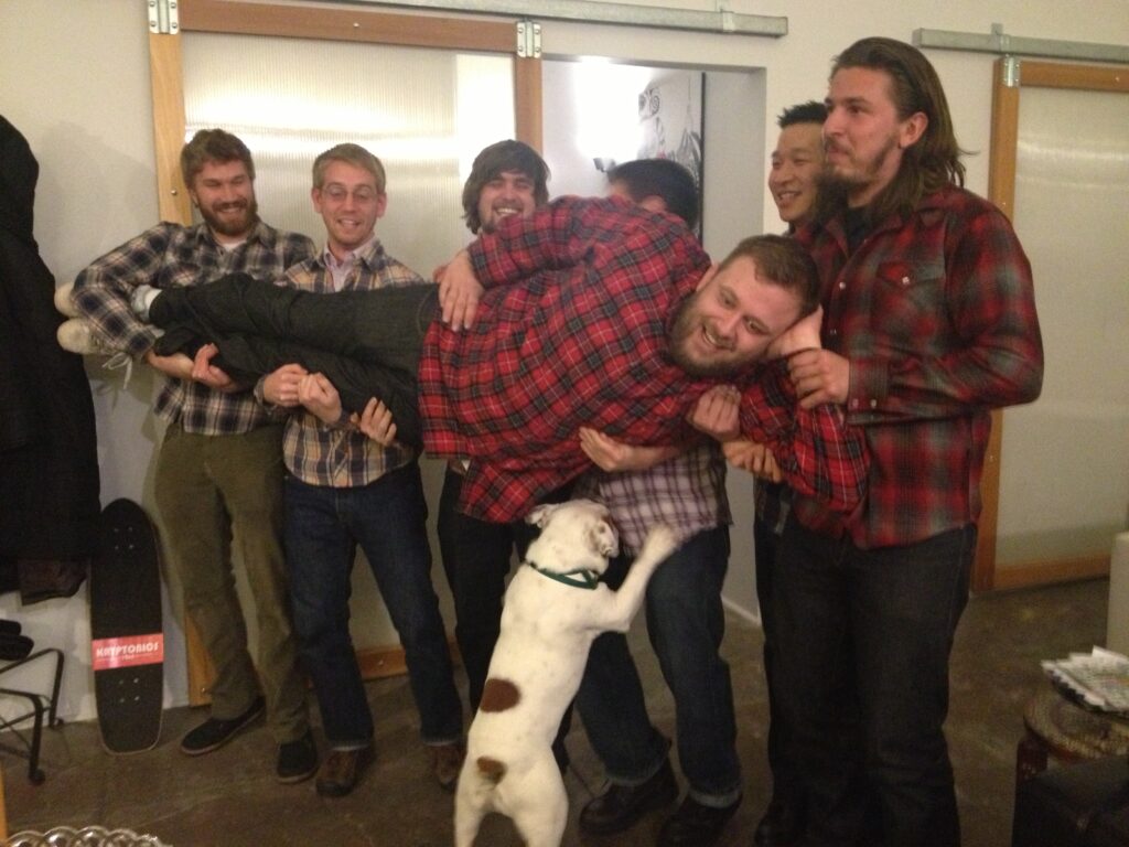 Ziggy jumping up on a posed picture with a bunch of guys wearing plaid shirts