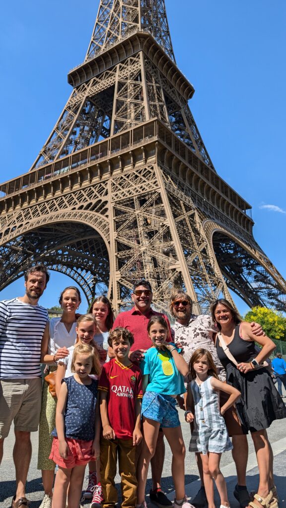 Brad and his family and neighbors posing in front of the Eiffel Tower