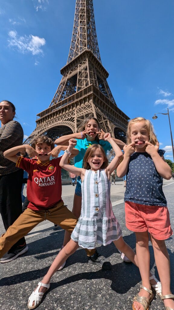 Ella and her neighbors posing in front of the Eiffel Tower