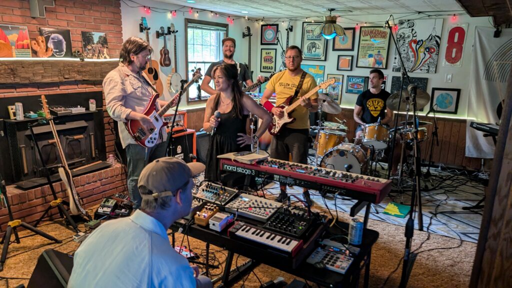 Daniel Hall, Dave Rupert, Melissa Frost, Will Schneider, Josh Sager, and Ian Frost practicing for Frostapalooza in Brad's basement