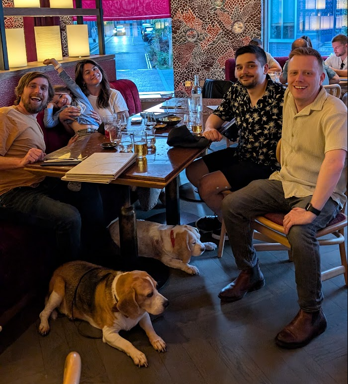 A group of people and two beagles sitting at a restaurant