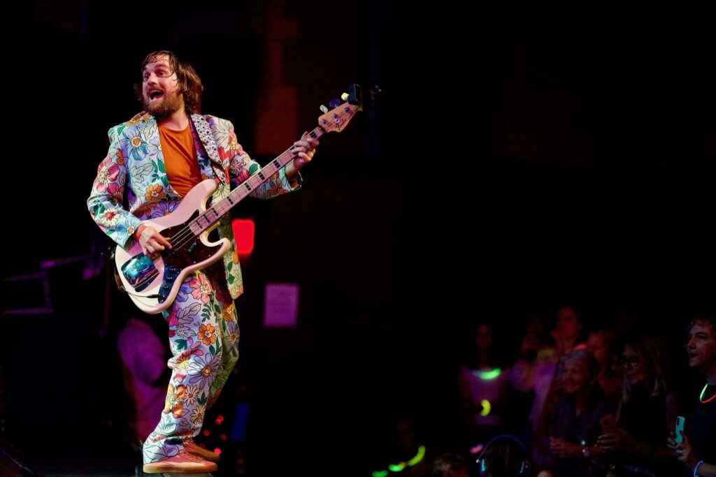 Brad with a bass guitar and a loud suit on stage at Frostapalooza