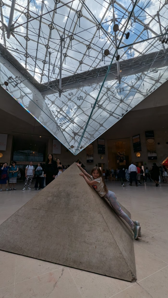 Ella posing at the inverted pyramids at The Louvre