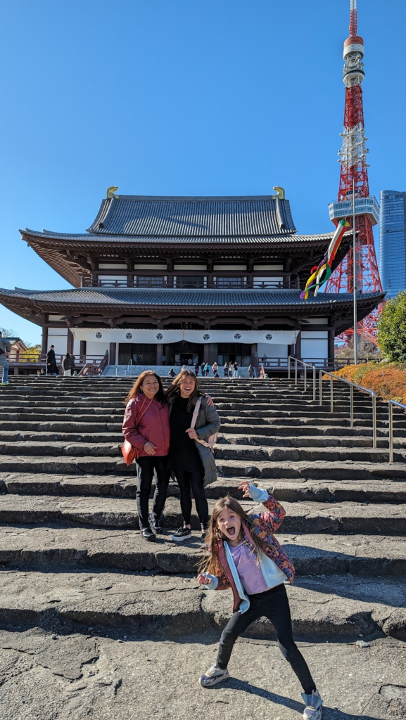 Brad's family posing at a temple with Tokyo Tower in the background